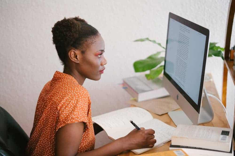 A dedicated business professional intently studying coursework on her computer to enhance her academic credentials and further her career growth.